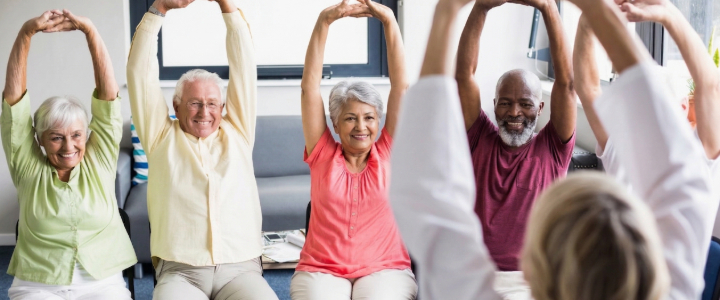 Warm senior living common area with diverse residents and engaged staff